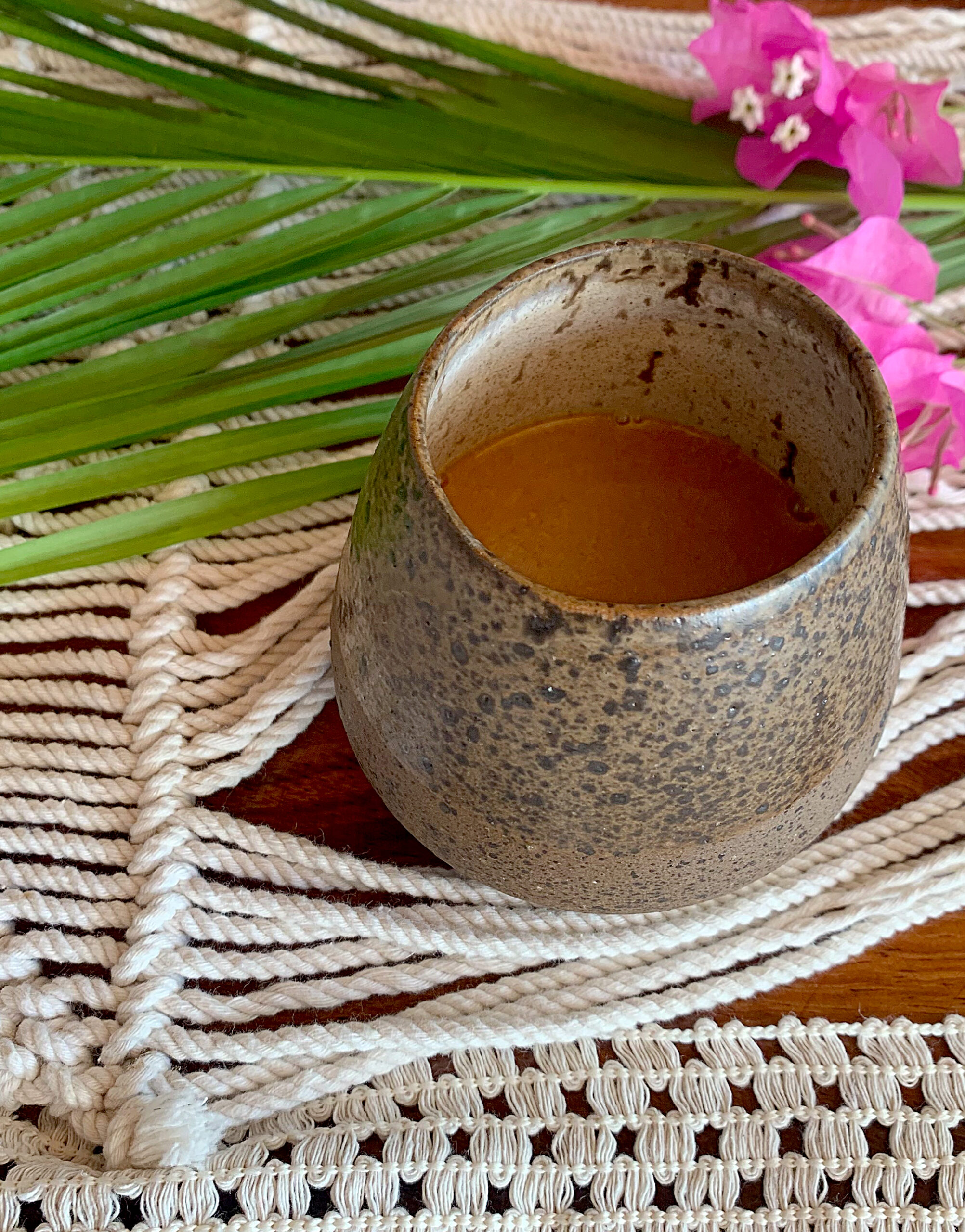 Top down view of coffee mug on dining table with macrame and flowers